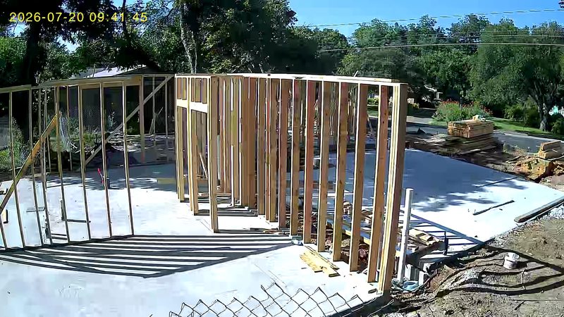 First wall frames standing on the slab, site camera
