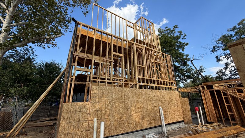 Sheathing climbing the side elevation, third-floor walls above