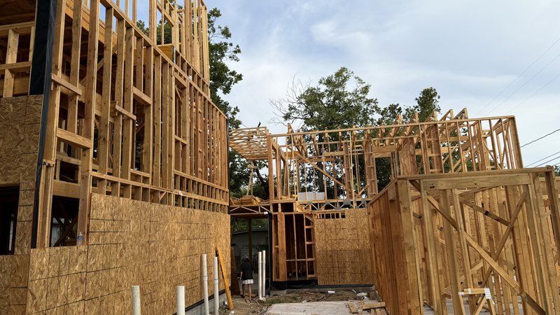 The shared lane between the homes, sheathed walls on both sides
